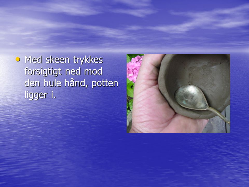 • Med skeen trykkes forsigtigt ned mod den hule hånd, potten ligger i.